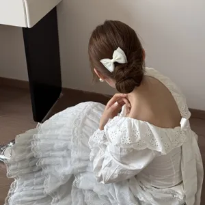 Close-up of an elegant white bow hair clip worn on a bun for a sweet Korean style