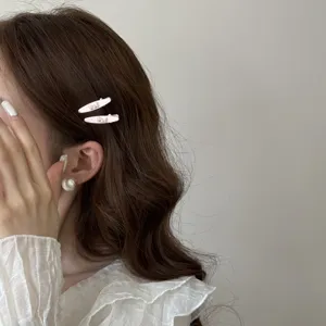 Close-up of sweet pink rhinestone bow duckbill hair clips worn on model side hair