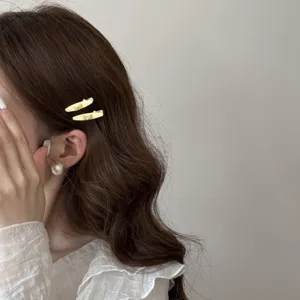 Close-up detail of elegant cream rhinestone bow hair clips on wavy brunette hair