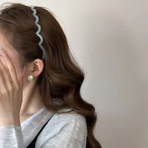 Détail de profil d'un serre-tête ondulé bleu gelée porté par un mannequin élégant
