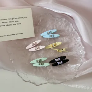 Assorted colorful rhinestone bow duckbill hair clips displayed on a decorative glass plate