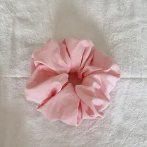 Vue détaillée du tissu en coton rose doux et des froufrous en forme de nuage du chouchou