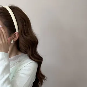 Gros plan d'un élégant serre-tête en satin fleuri créant un look chic sur un modèle
