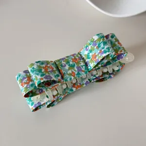 Détail d'une barrette à cheveux vintage en tissu à imprimé fleuri avec ressort