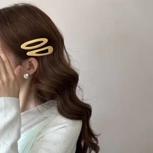 Gros plan de barrettes à cheveux en tissu jaune à pois sur cheveux bruns ondulés
