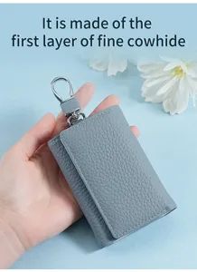 Close-up of premium grey first layer cowhide leather folding key case wallet in hand