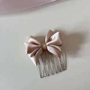 Detalle del lazo de satén champán en un peine para el cabello de metal plata