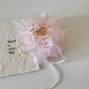Close-up view of pink bubble mesh hair claw clip with elegant organza fabric texture