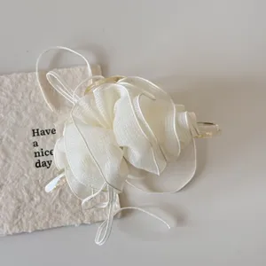Detailed view of the layered mesh ruffles and sturdy claw on this off-white hair clip.
