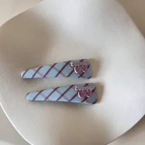 Close-up of blue and purple plaid hair clips with heart-shaped Sweety decoration