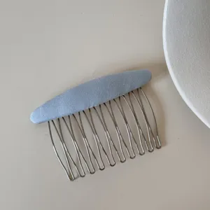Vista dettagliata di un pettine per capelli minimalista in metallo azzurro chiaro