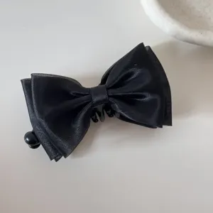 Detailed macro view of a black mesh bow hair clip with a sweet and elegant design.