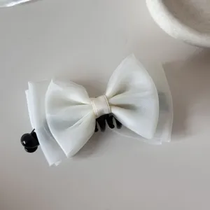 Top view of a sweet white mesh bow hair clip with black comb base