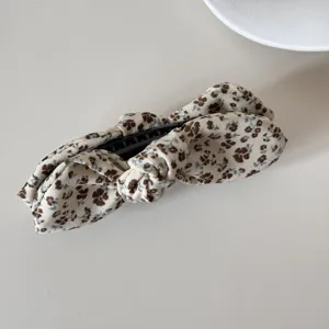Close-up shot of a vintage floral pattern bow hair clip showing detailed fabric texture