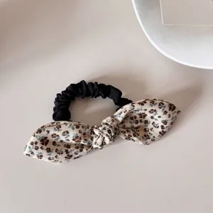Detailed view of a vintage floral bow scrunchie with delicate blue and brown patterns.