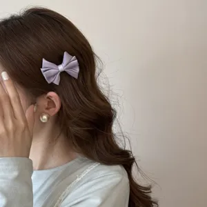 Détail en gros plan d'une élégante pince à cheveux en satin violet sur des cheveux.