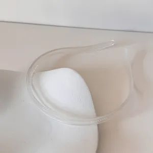 Gros plan d'un serre-tête minimaliste transparent sur un support blanc