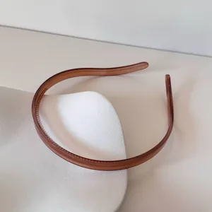 Vue latérale détaillée d'un serre-tête minimaliste marron gelée avec dents antidérapantes