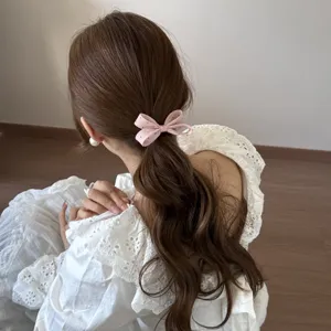 Gros plan d'un joli chouchou rose à pois avec un nœud en tissu dans une queue de cheval.