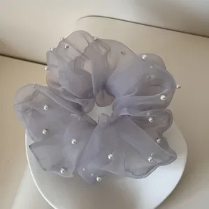 Detail view of grey mesh scrunchie with delicate faux pearl accents and ruffled edges.