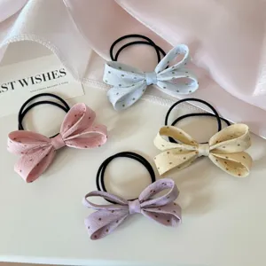 Gros plan d'élastiques à nœuds à pois pastel en rose, bleu, jaune et violet clair