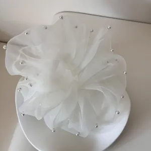 Close-up detail of a sweet white mesh hair scrunchie with elegant pearl edge accents
