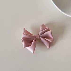 Gros plan sur une élégante pince à cheveux en satin rose avec un design multicouche