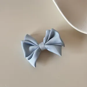 Vue détaillée d'une barrette à nœud en satin bleu clair élégante avec texture de soie
