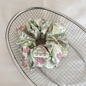 Gros plan d'un chouchou à fleurs avec étiquette placé dans un panier métallique.