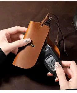 Detail view of vintage brown Crazy Horse leather car key cover case held open by hand
