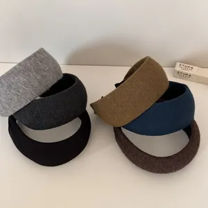 Macro view showing the soft knitted texture of multiple colored wide-brimmed headbands