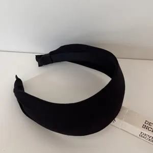 Close-up of a premium black thickened wide-brimmed headband with elegant striped texture detail.
