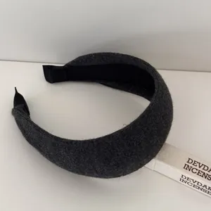 Detailed view of a dark grey knitted wide headband featuring a thick ribbed texture