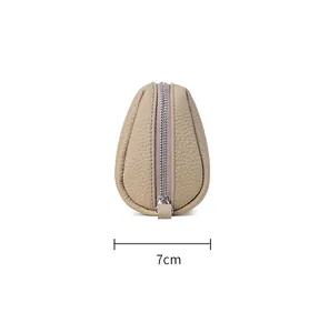 Vista lateral de un neceser compacto de cuero beige con indicación de ancho de 7 cm