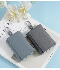 Close-up of two premium leather key pouches in blue and grey showing detailed texture