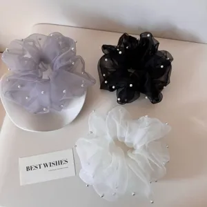 Detailed view of elegant lace mesh scrunchies with white pearl accents in three colors
