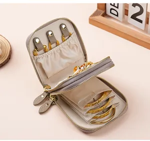 Interior detail of a double-layer leather jewelry storage organizer with gold bracelets