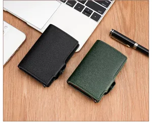 Detail view of minimalist pop-up card wallets in black and green leather on wooden desk.