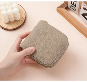 Close-up view of a pebble grain leather jewelry pouch being held in a woman's hand.