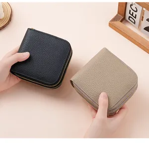 Close-up view of two double zipper pebbled leather jewelry organizers in black and taupe