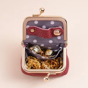 Mini leather jewelry pouch in burgundy with gold clasp, showing rings and necklaces storage