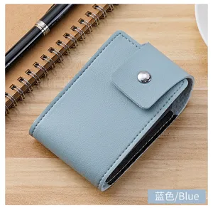 Detaillierte Nahaufnahme eines hellblauen Leder-Kartenhalters mit einem Druckknopf