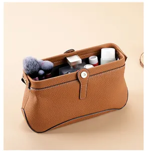 Detailansicht der braunen Echtleder Kosmetiktasche mit feiner Narbung und Bügelverschluss.