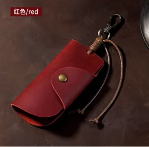 Macro detail of a red crazy horse leather key pouch with a vintage brass snap button