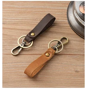 Detailed view of handmade vintage Crazy Horse leather keychains in dark and light brown