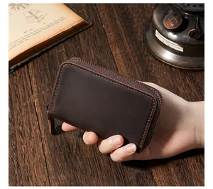 Detailed handheld view of a vintage dark brown crazy horse leather zipper key case
