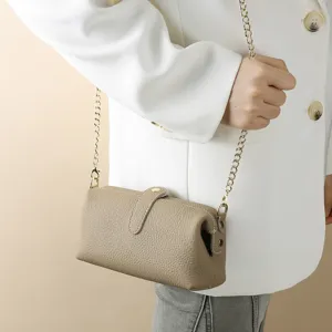 Genuine leather toiletry bag with detachable gold chain strap worn as a shoulder bag