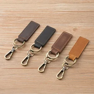 Vintage crazy horse leather car keychains in four colors on a light wooden background