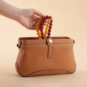 Hochwertige Kosmetiktasche aus Narbenleder mit stilvollem Perlengriff für Damen. Hauptansicht.