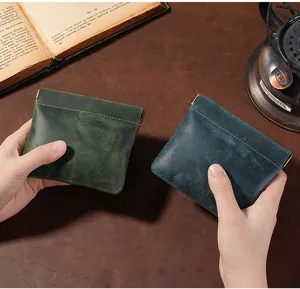 Close-up detail of green and blue crazy horse leather mini pouches with squeeze closure mechanism